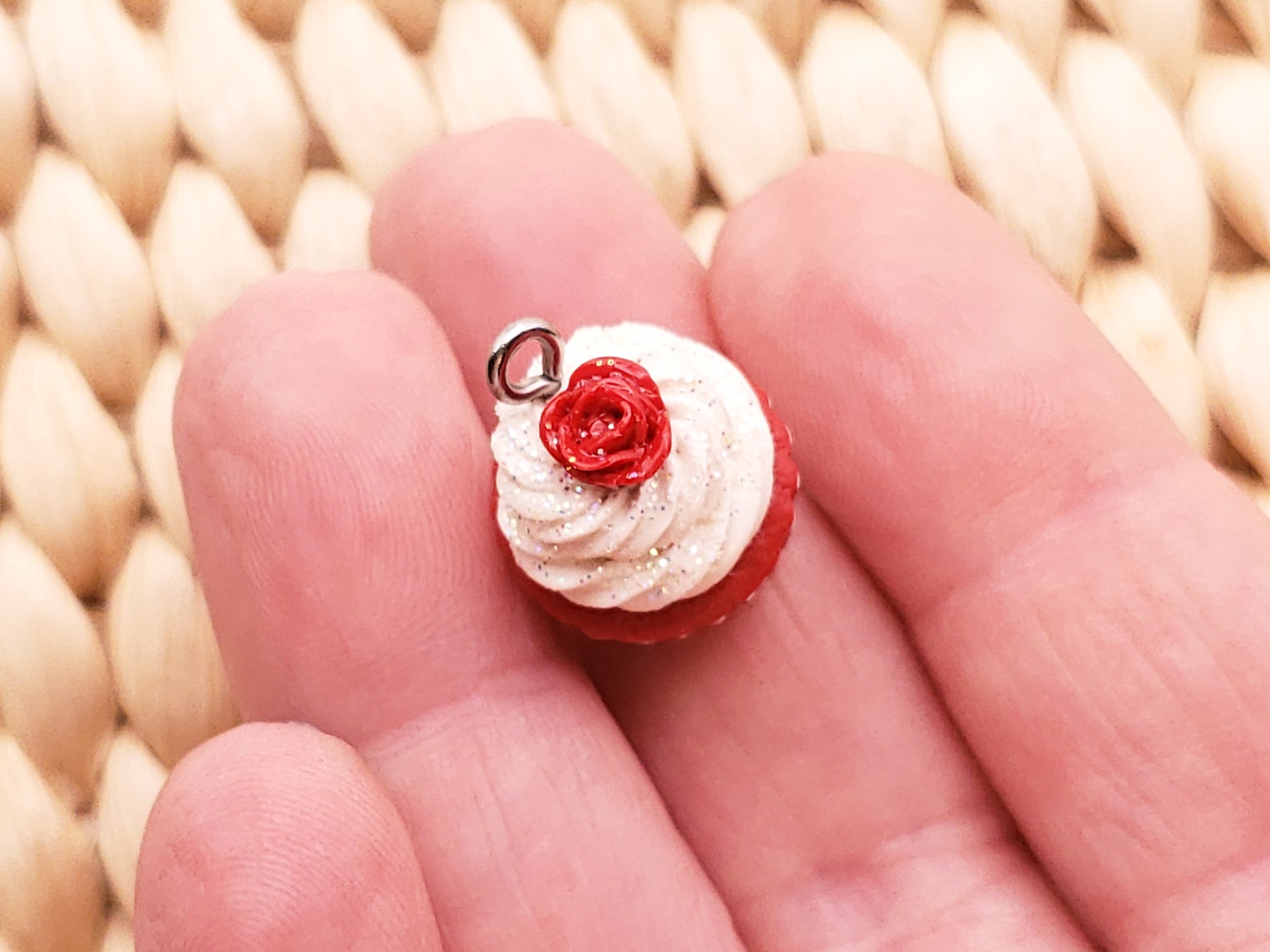 a tiny red and white cupcake with a rose on top