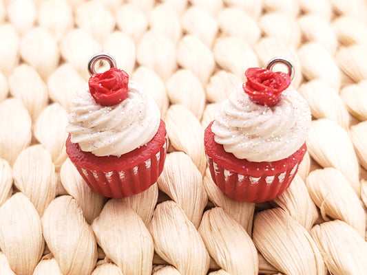 two cupcakes with white frosting and red bows