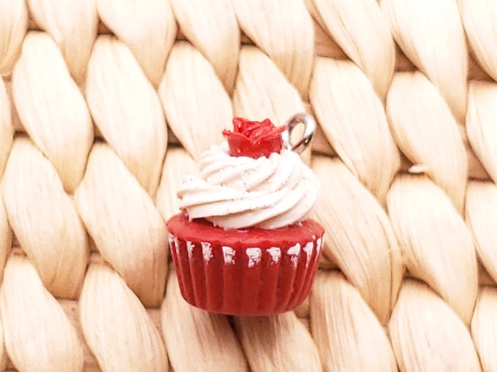 a red cupcake with white frosting and a red bow